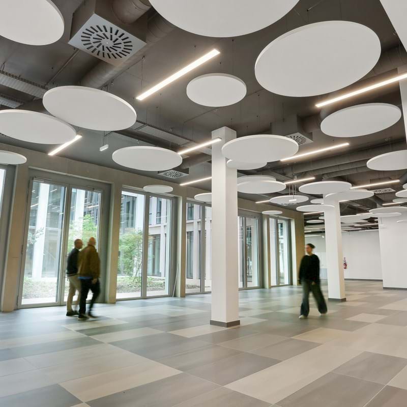 Ecophon Solo Circle installati a soffitto con persone che li osservano