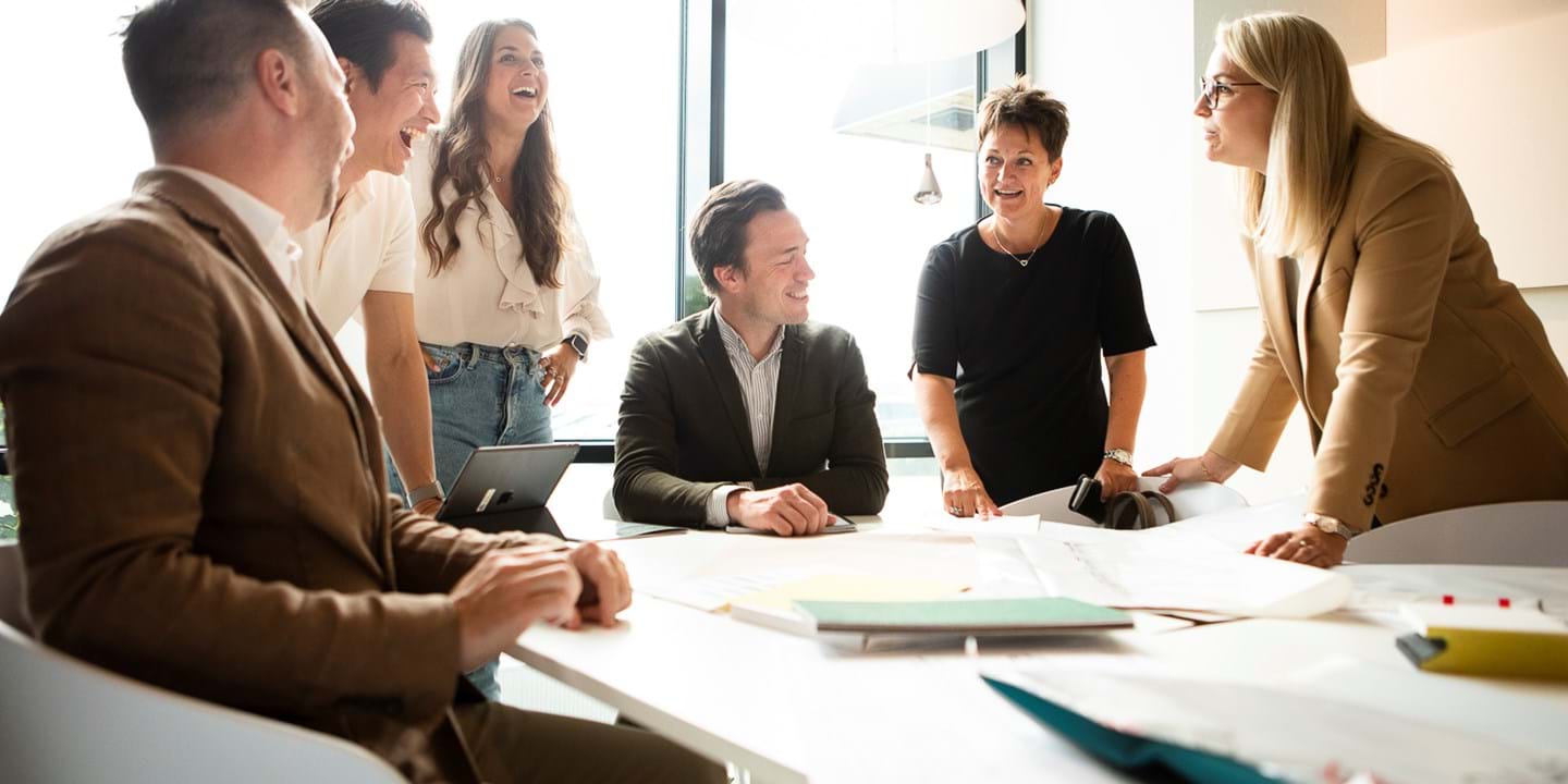 Ecophon co-workers in conference room talking and laughing