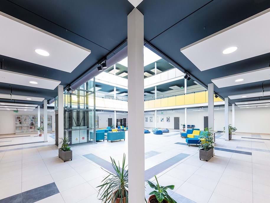 Free-hanging acoustic panels in school atrium