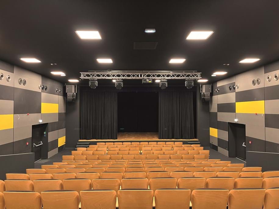 Black suspended acoustic ceiling and acoustic wall panels in dark grey, light grey and yellow in concert and theatre hall
