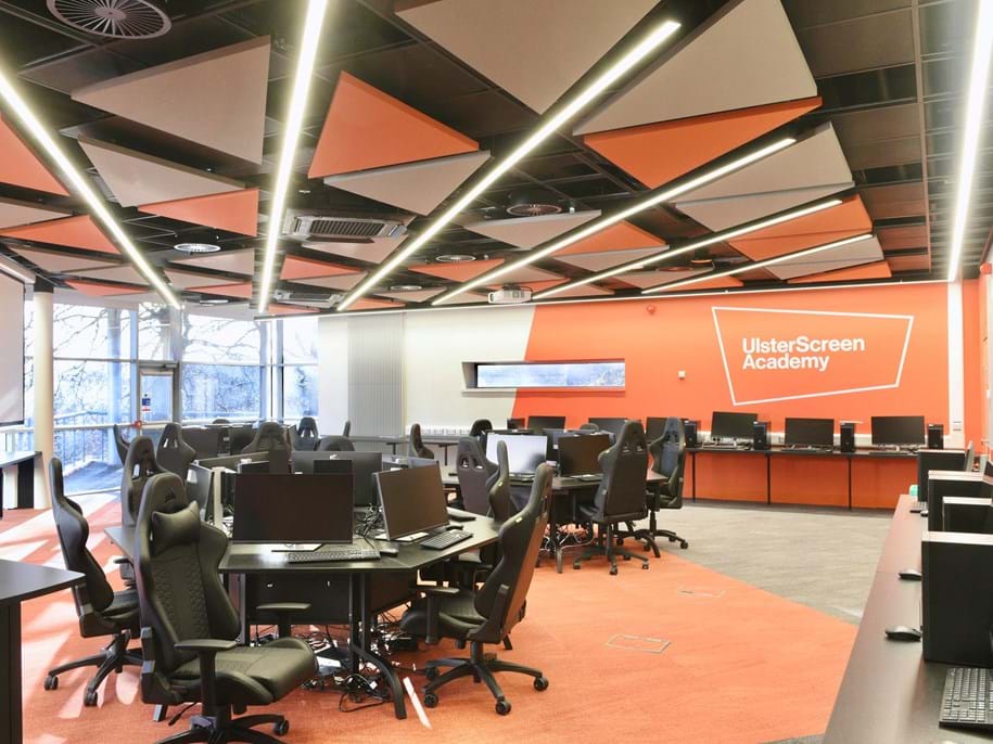 Triangle-shaped, free-hanging acoustic panels in different colours in computer science classroom
