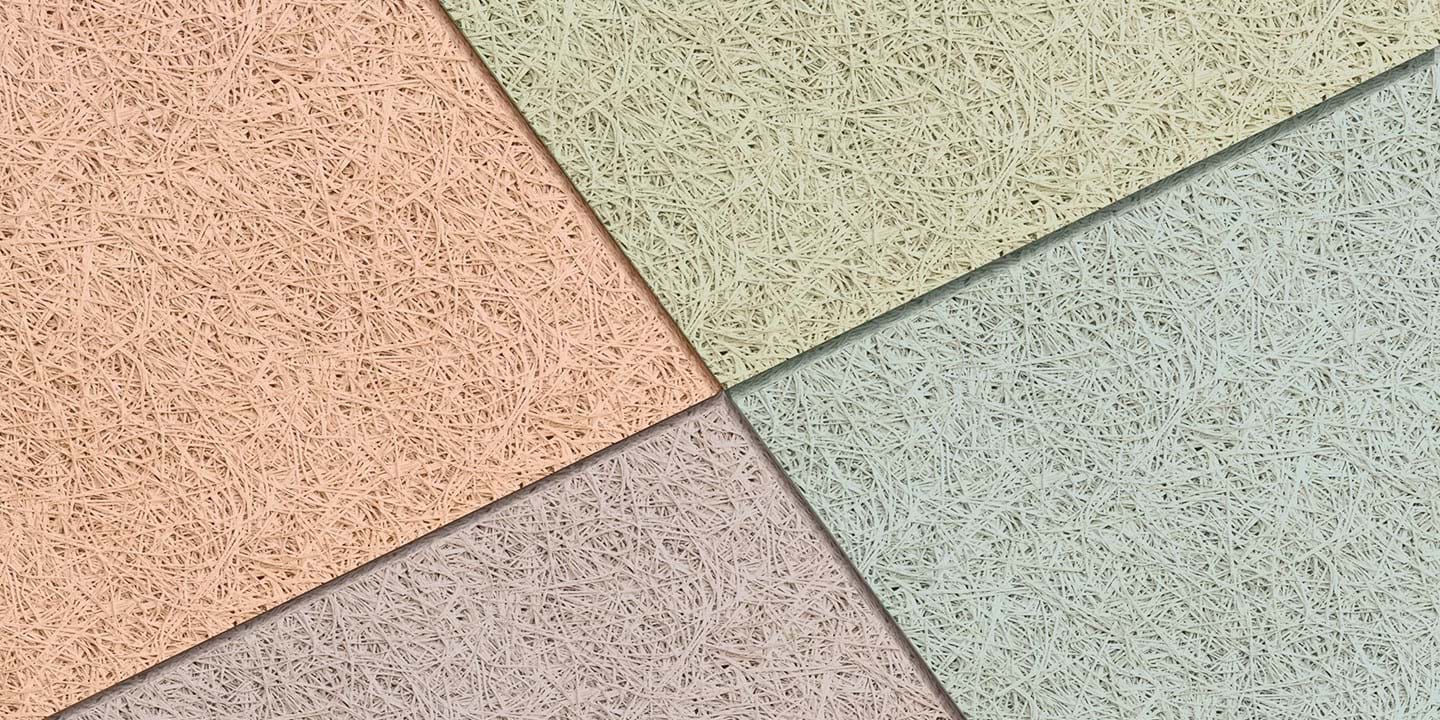 Nahaufnahme von Holzwolle-Akustikplatten in verschiedenen Pastellfarben