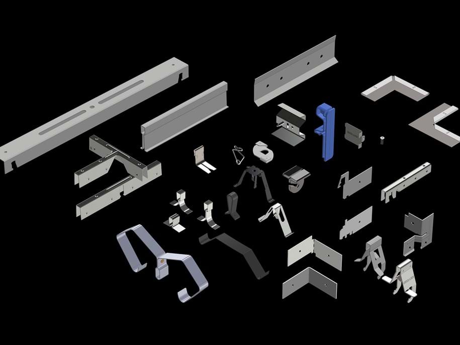 A collection of various metallic components and brackets with different shapes and sizes arranged on a black background. Some pieces are angular, while others include curves and flat surfaces, illustrating a diverse range of industrial parts.